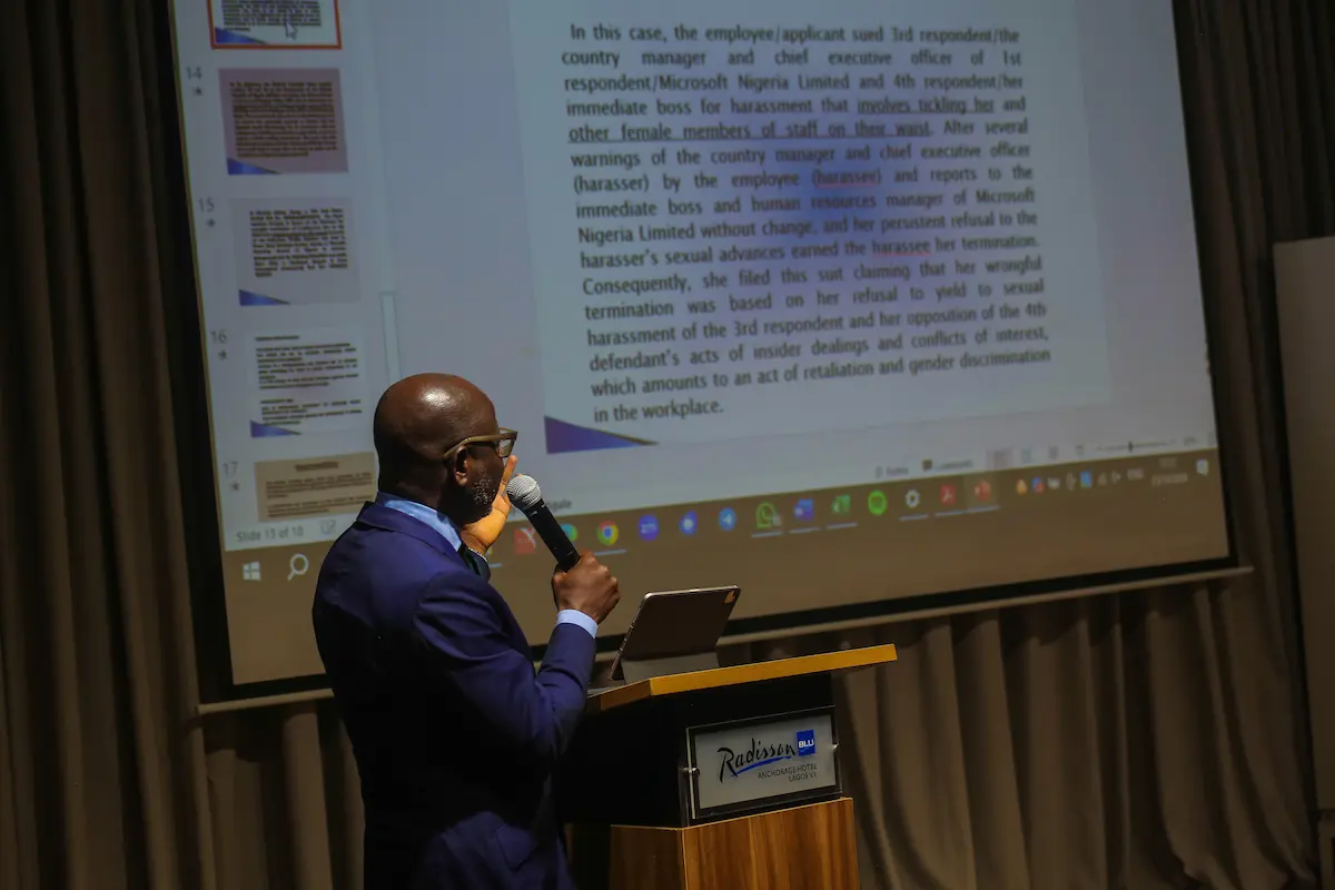 African executive leader in formal dress addressing a hall